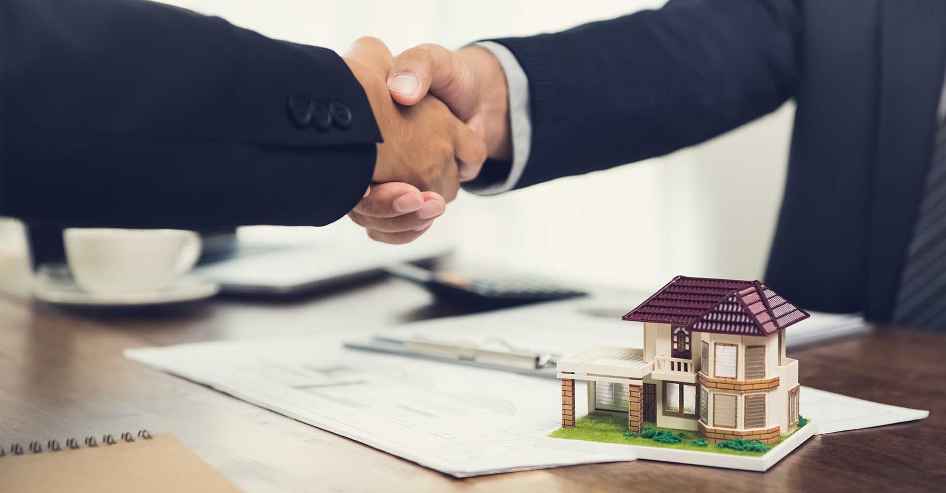 Real estate agent or architect making handshake with client after signing agreement in the meeting